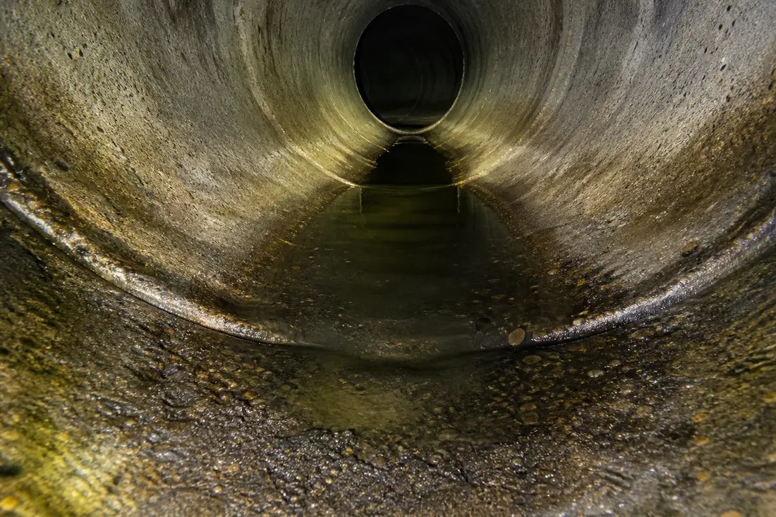 Zone de contre-pente dans une conduite où l'eau stagne, mise en évidence lors d'un diagnostic par caméra